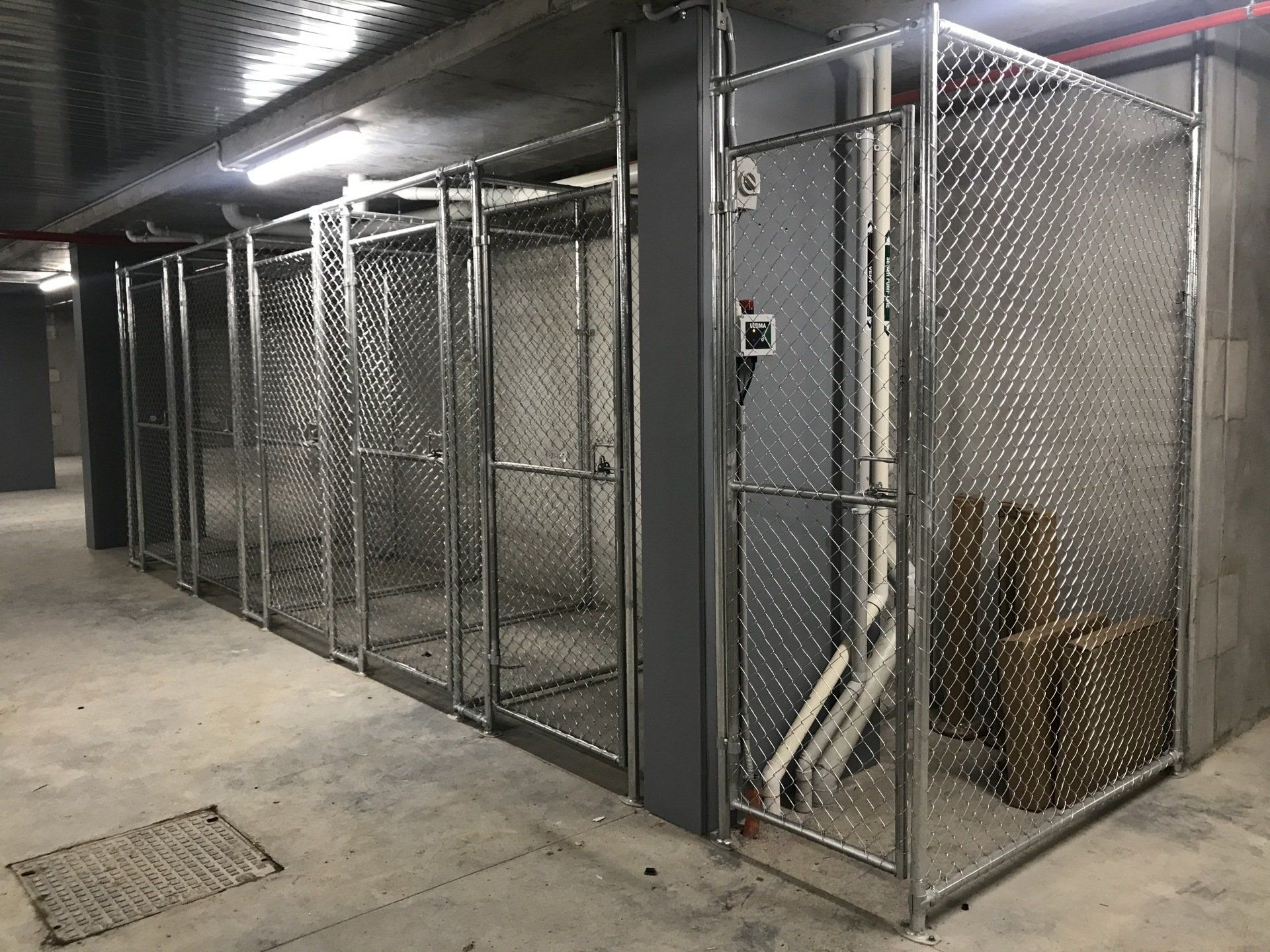 Row of chain mesh storage cages in an apartment basement