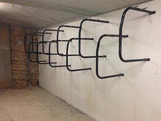 Row of hanging type bike racks on a wall