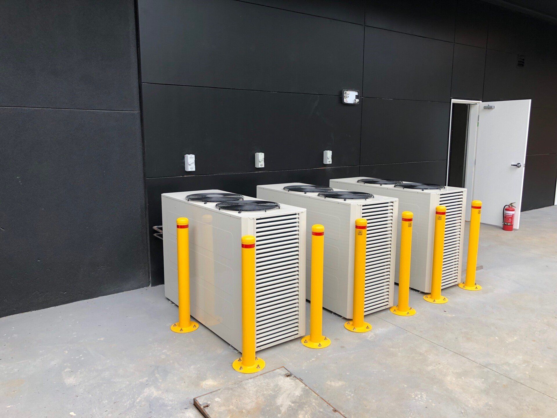 90mm Yellow bollards installed to protect air conditioning condensers