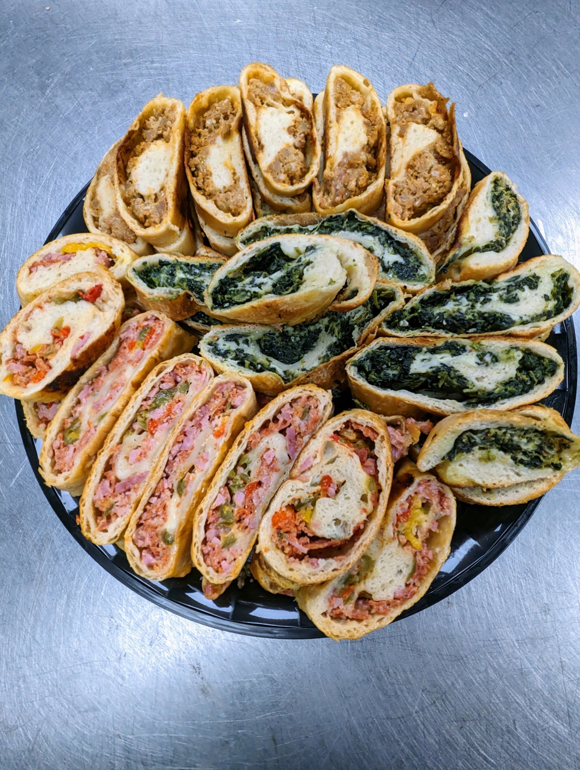 A tray of Italian rolls cut up and displayed in a circle.