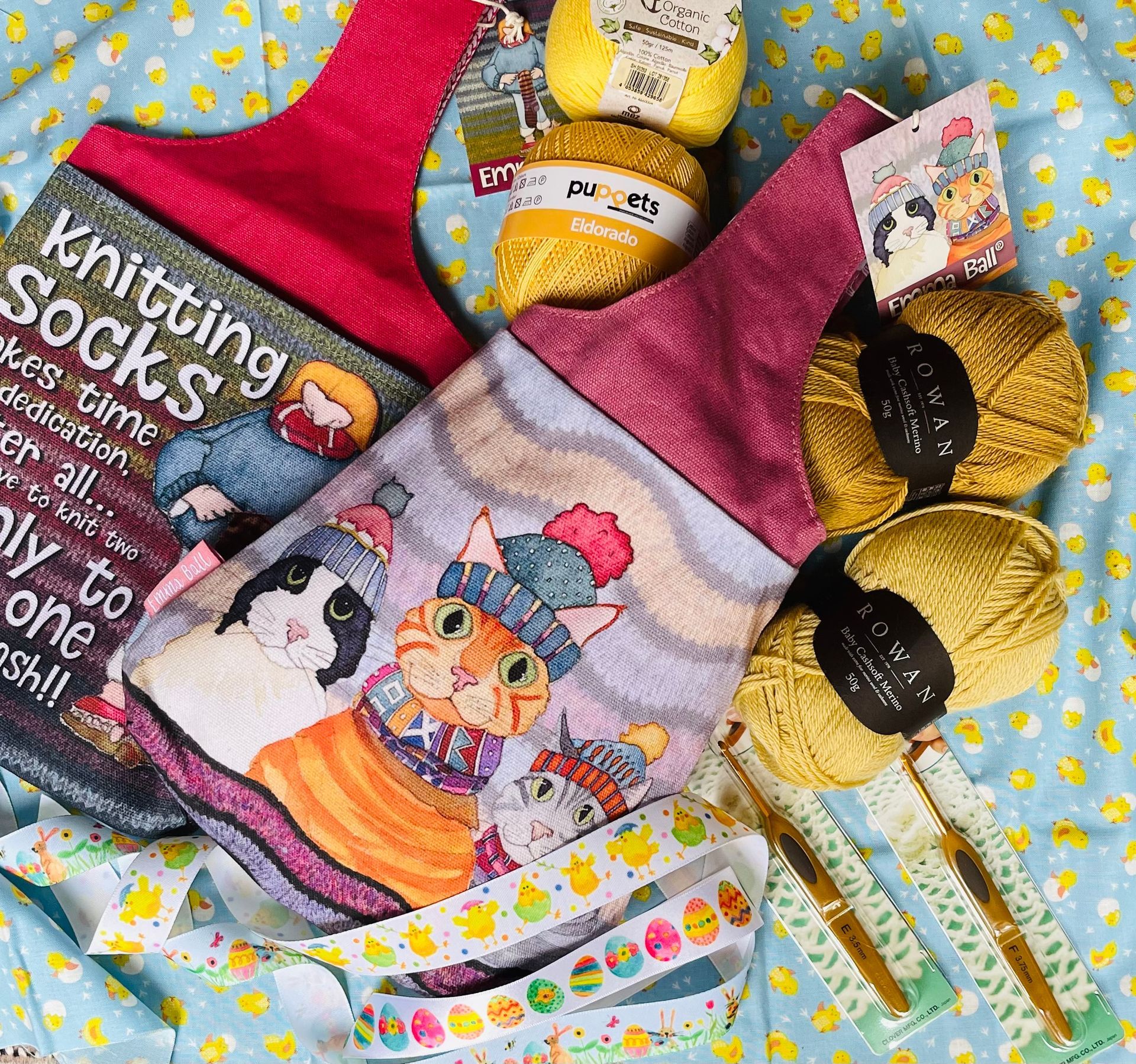 A book about knitting socks is sitting on a table next to yarn balls.