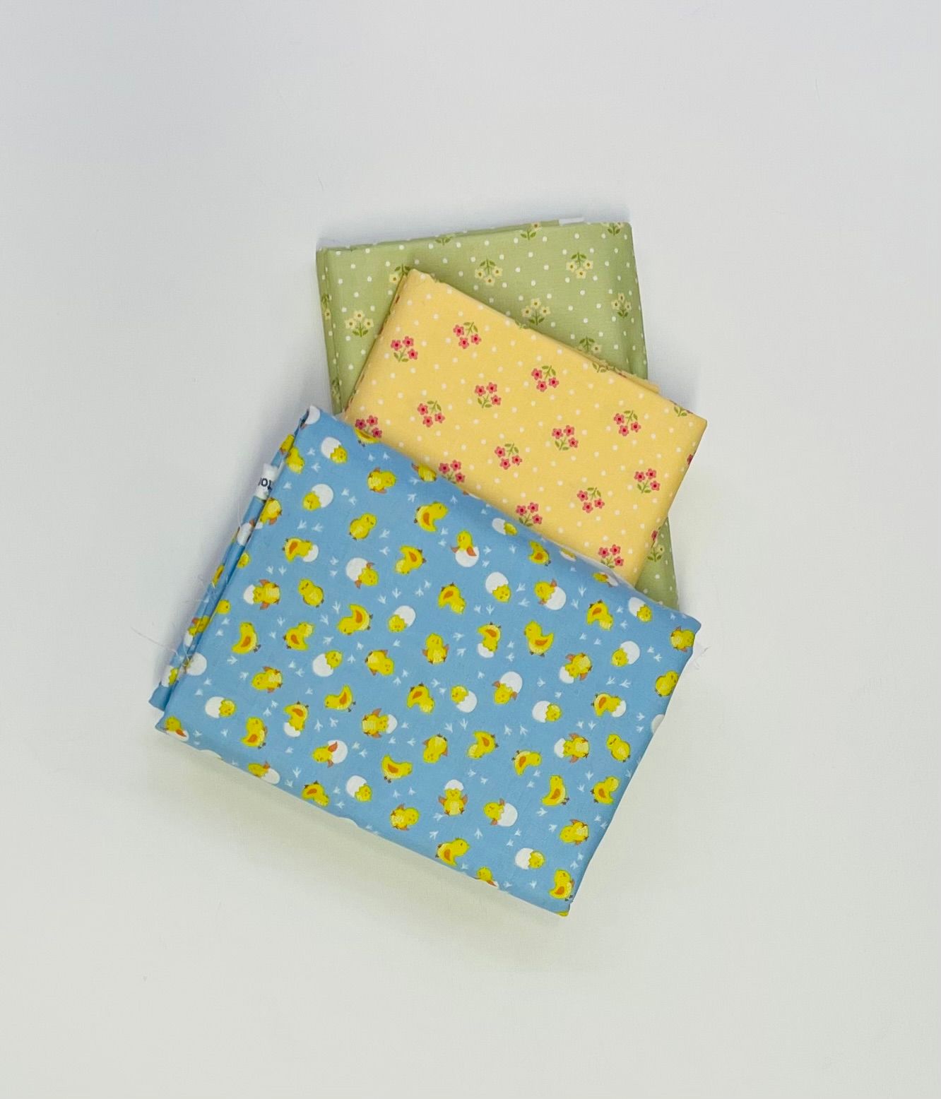 Three pieces of fabric with ducks on them are stacked on top of each other.