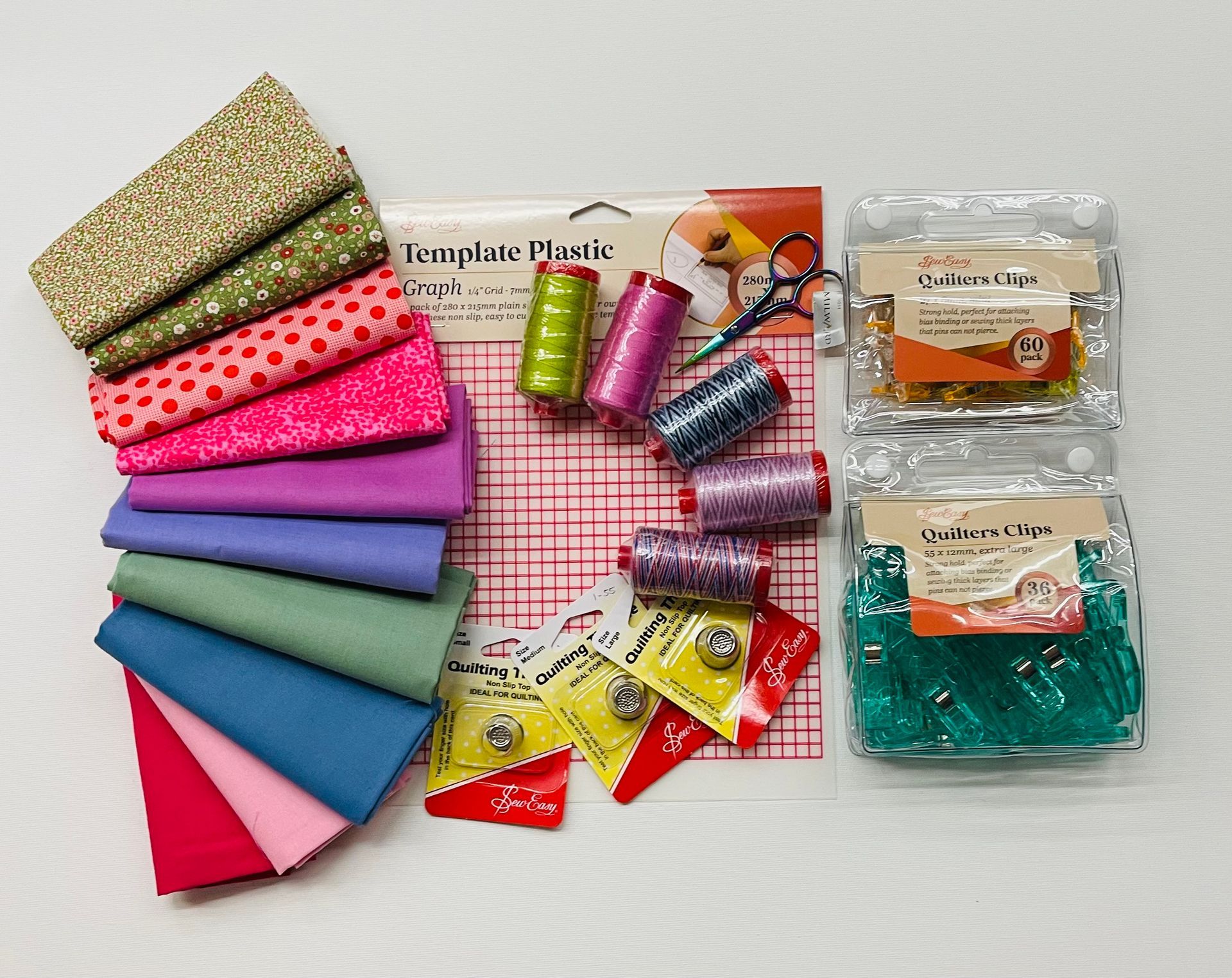 A bunch of sewing supplies including spools of thread pins and scissors