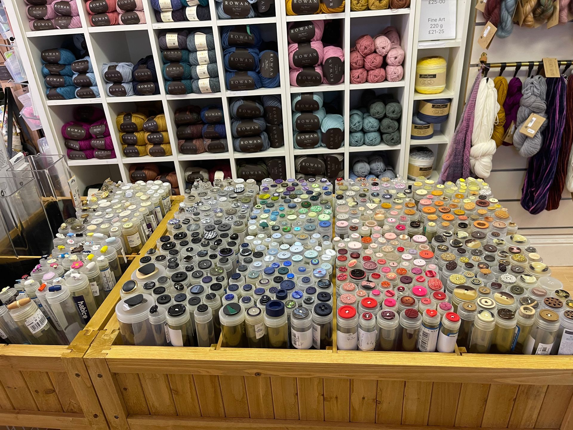 Rows of yarn skeins and colorful craft supplies displayed in a shop aisle