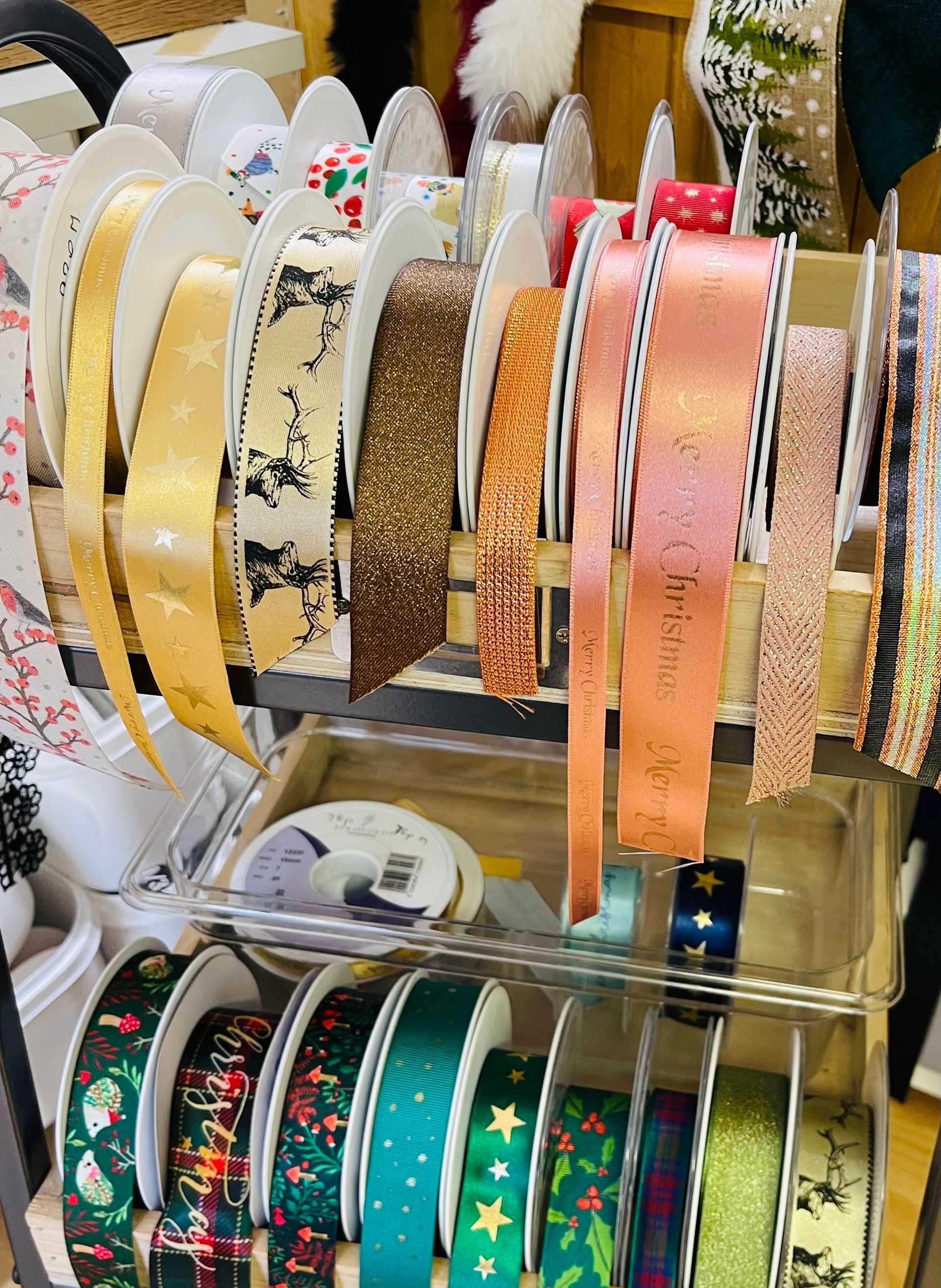 Ribbon display: gold, patterned, and glittery ribbons in various colors and designs, on shelves.