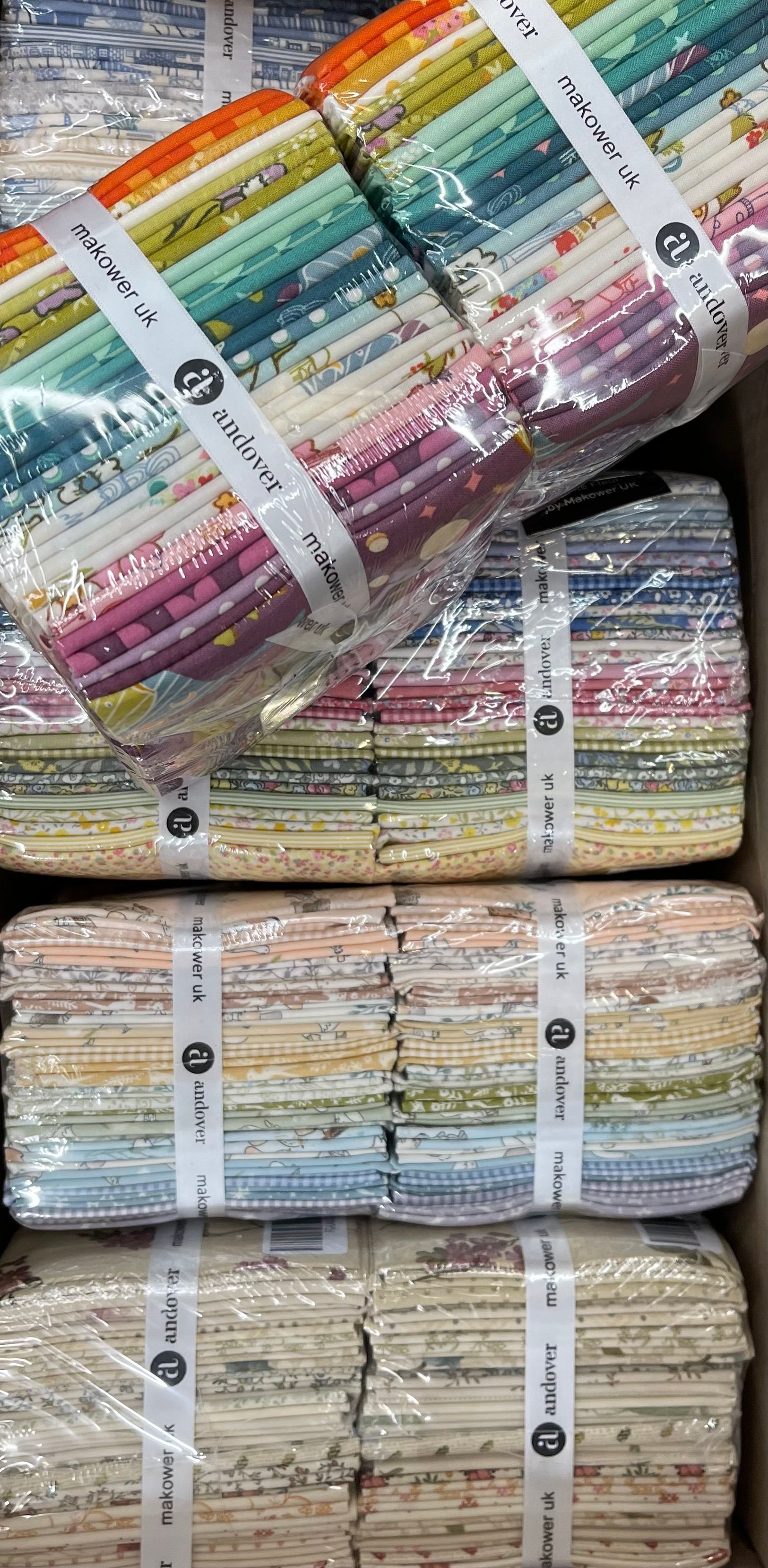 Stacked bundles of colorful folded textiles or mats wrapped in plastic and tied with white straps