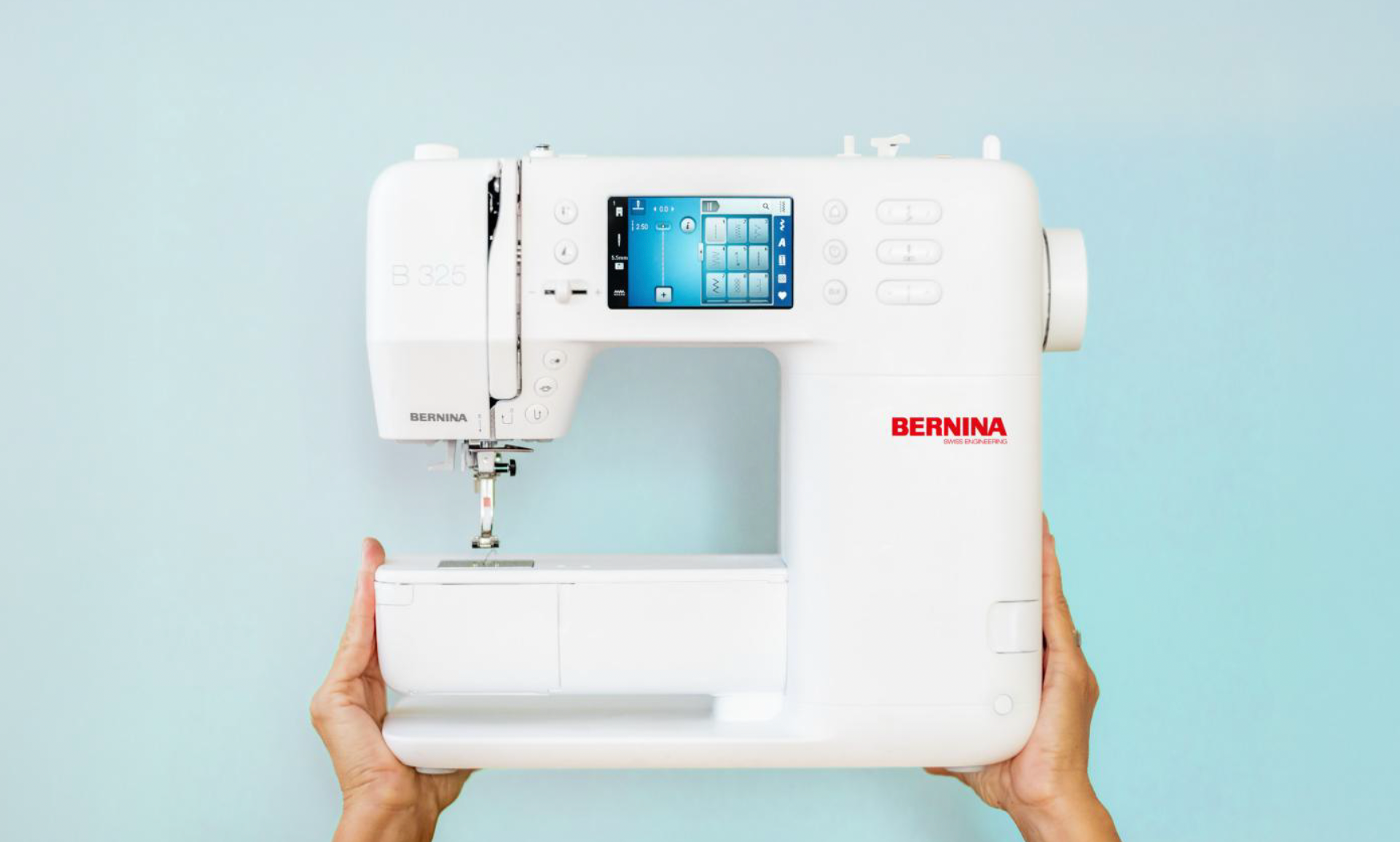 A person is holding a white sewing machine in their hands.