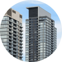 Two tall buildings in a circle with a blue sky in the background.