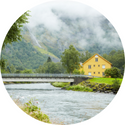 A bridge over a river with a house in the background.