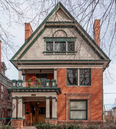 A large brick house with a wreath on the porch