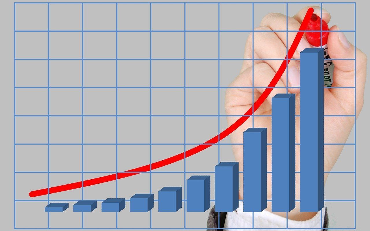 A person is drawing a graph with a red marker.
