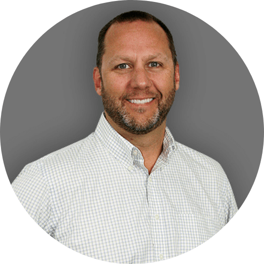 A man with a beard wearing a white shirt is smiling in a circle.