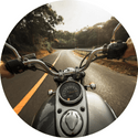 A person is riding a motorcycle down a road.