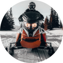 A man is riding a snowmobile in the snow.