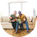 A man and woman are sitting on a couch with two children.