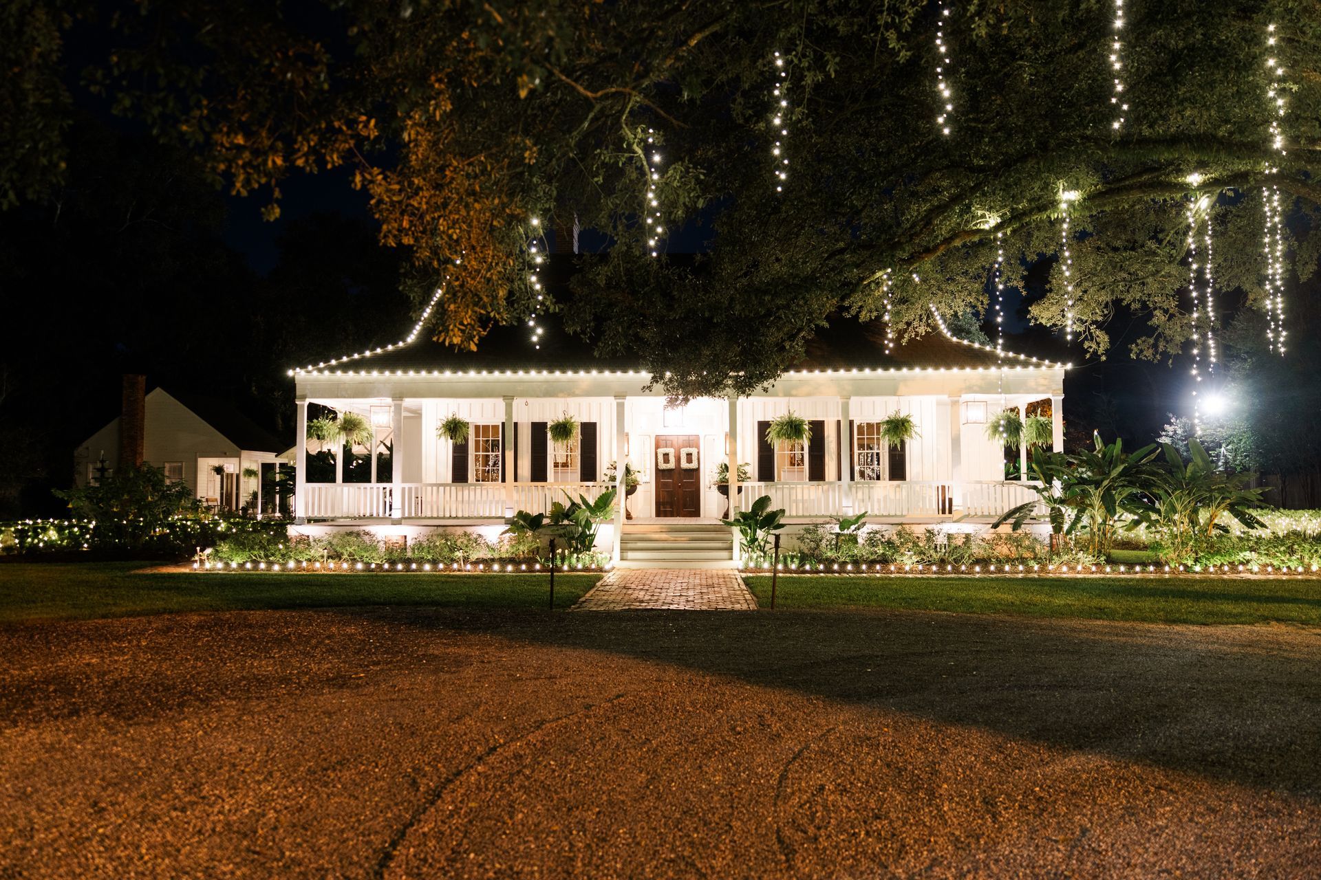 White house decorated with lights at night.