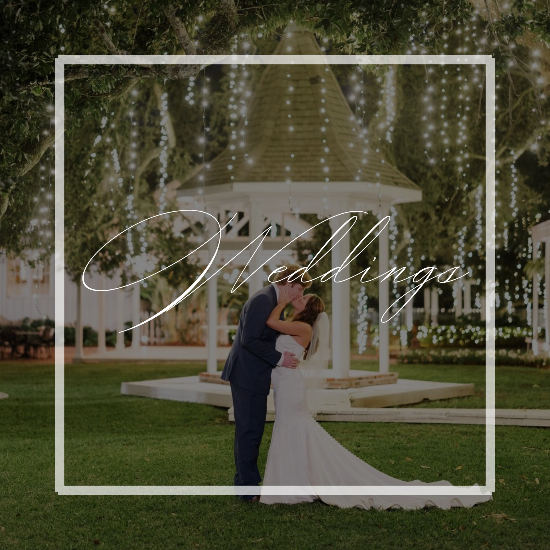 Couple kissing at outdoor wedding ceremony near gazebo with string lights.