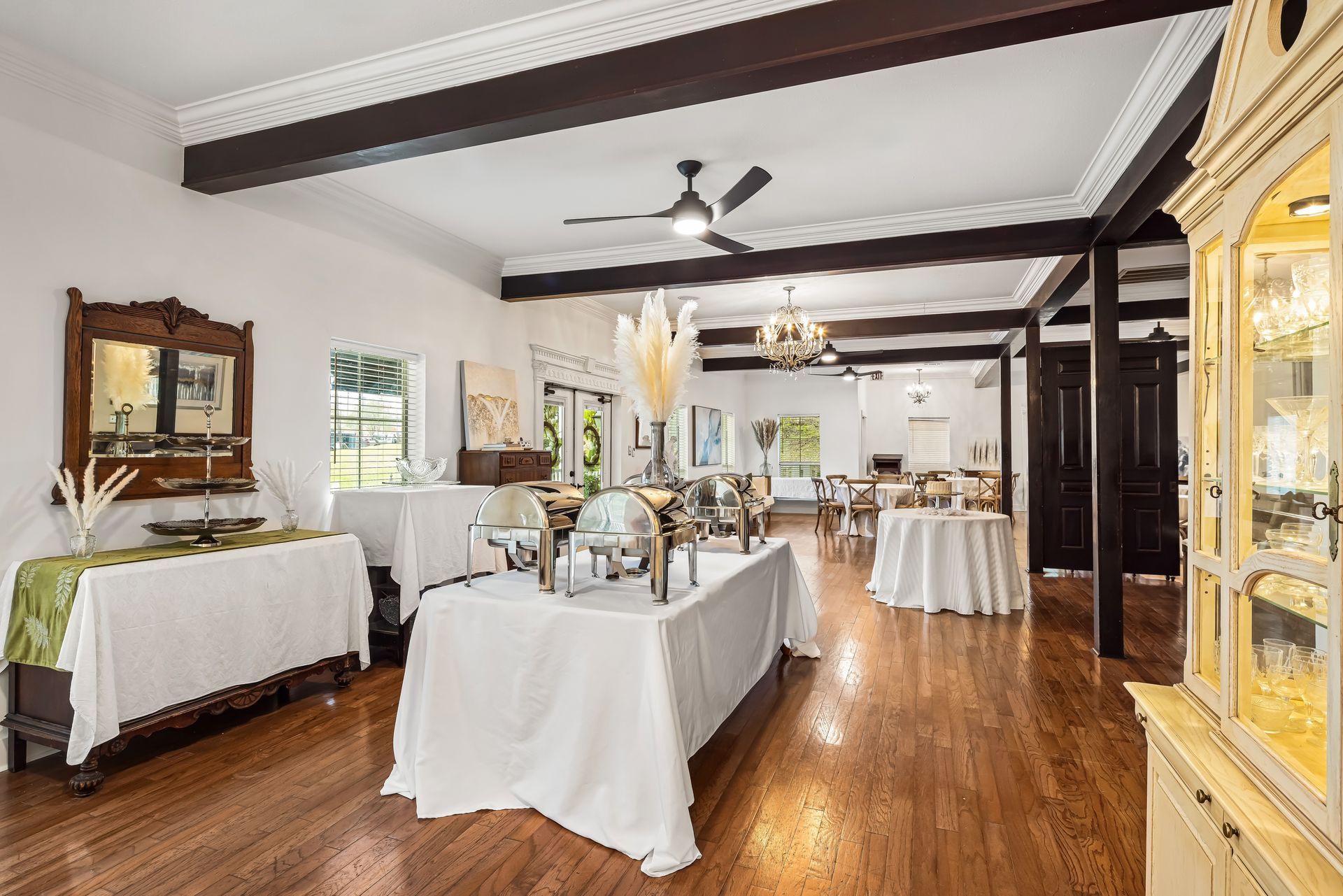 Event space with white tables, wooden floors, and decor.