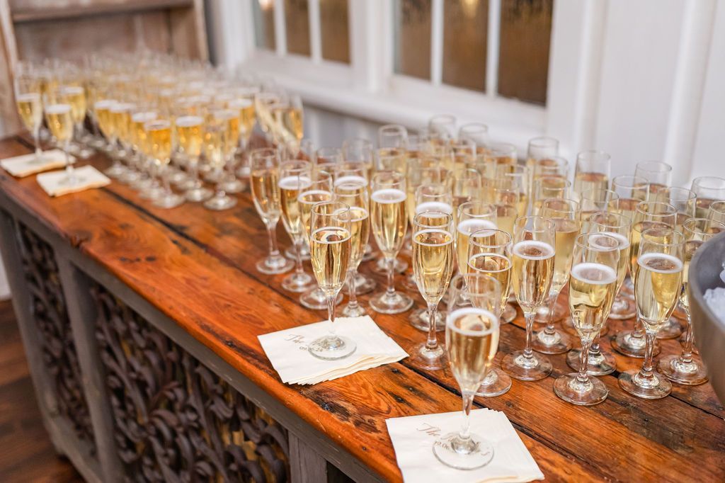 Champagne flutes arranged on a wooden bar, ready for a celebration.