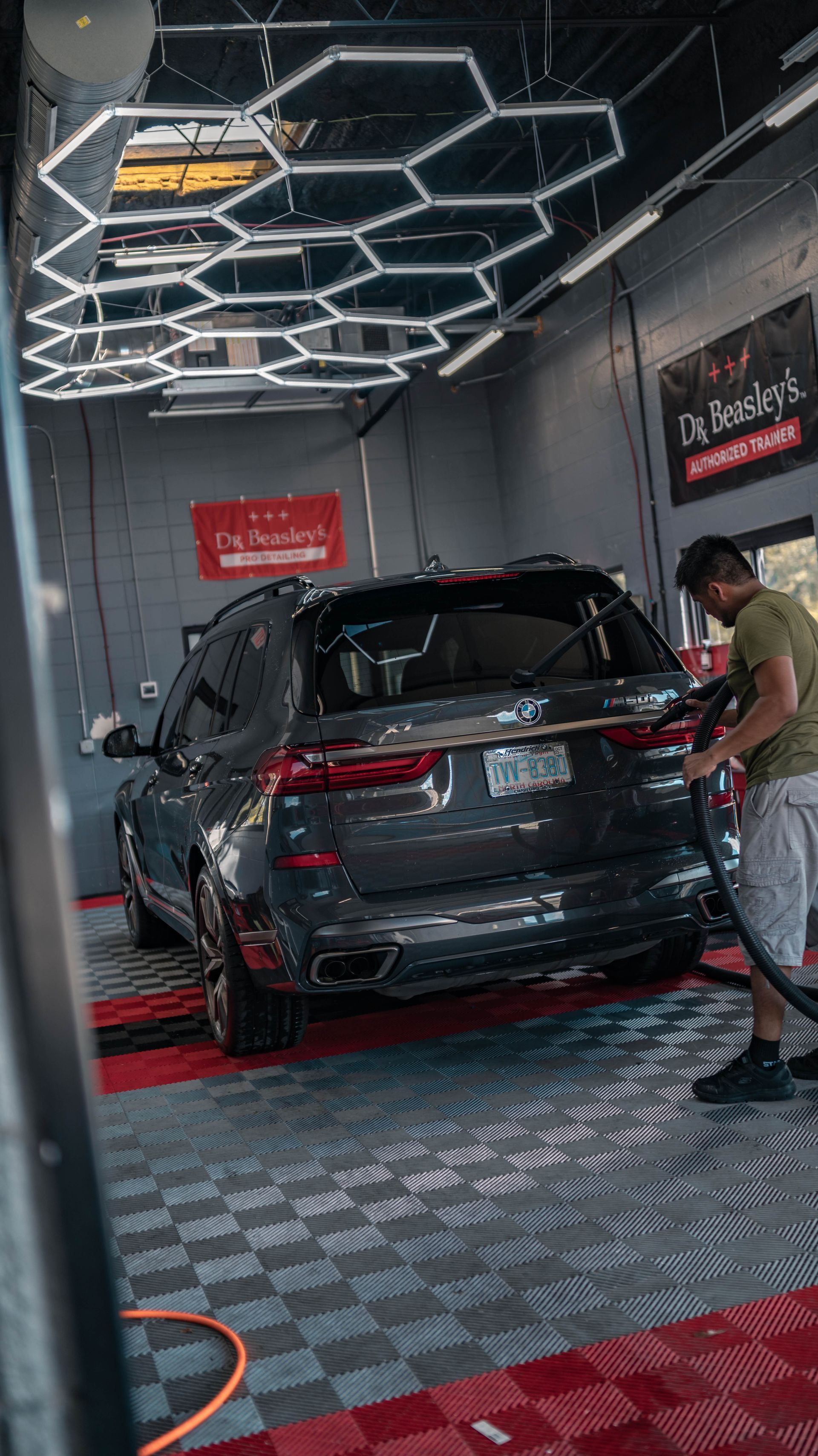 A man is washing a car in a car wash.