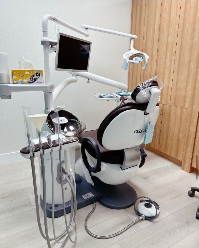 Dental treatment chair with mounted monitor and instruments in a modern clinic room