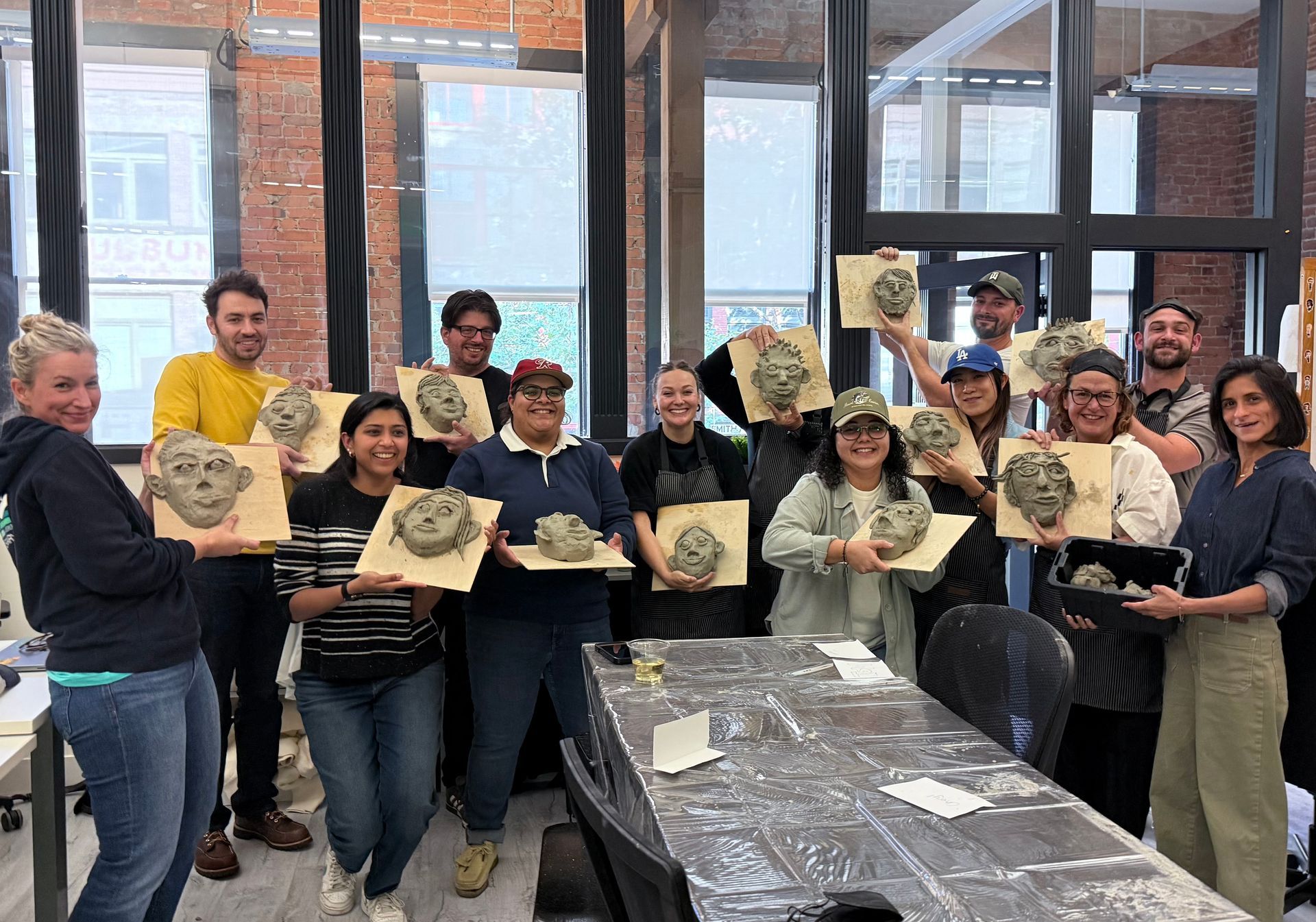 group holding up clay heads