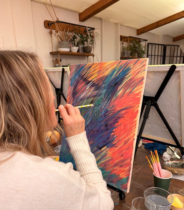woman Painting on a panel with a straw