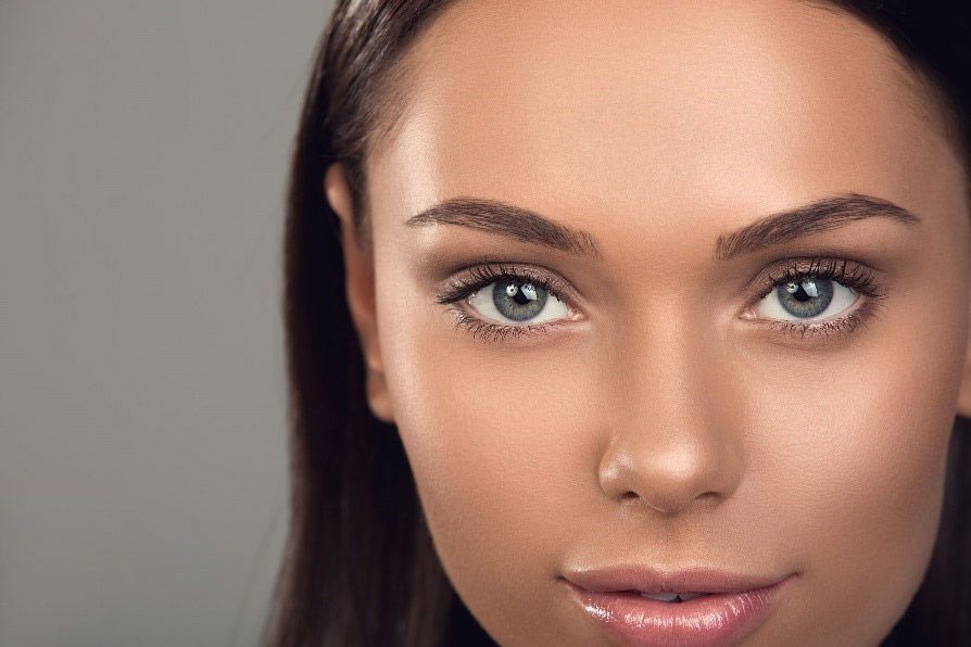 Close-up of a woman with tan skin, gazing at the camera with neutral expression.