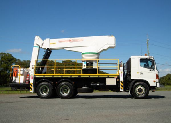 A white truck with a crane on the back of it
