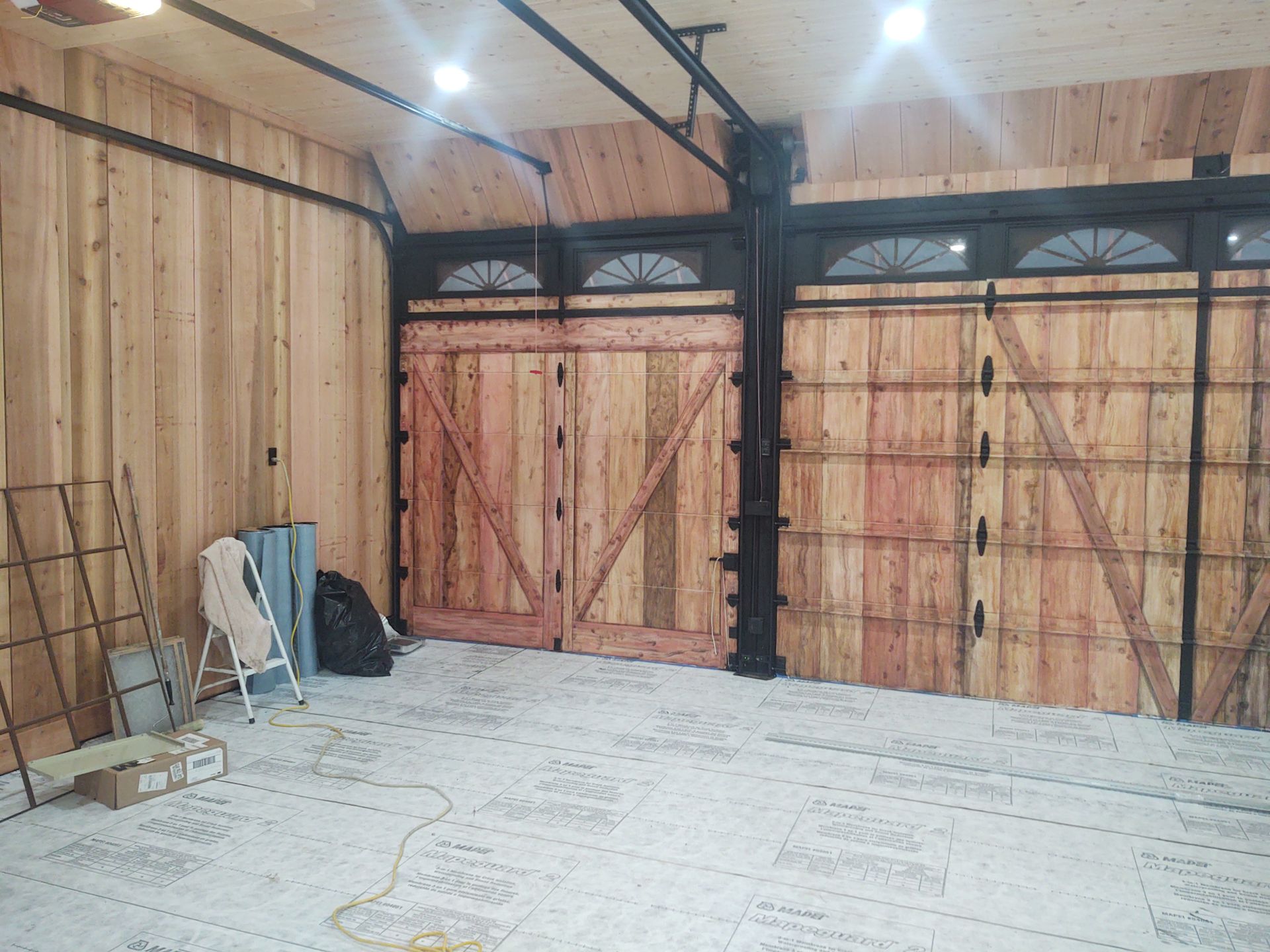 A garage with wooden walls and sliding barn doors.