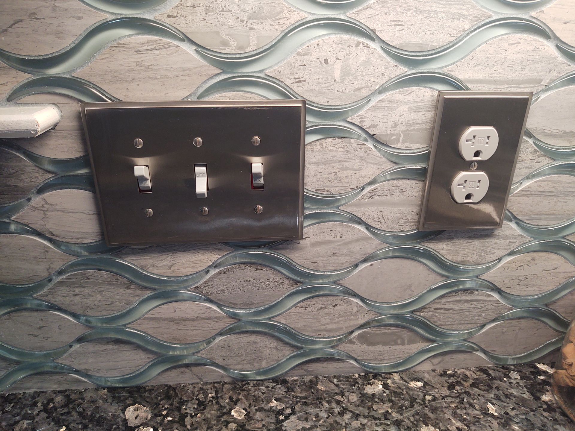 A light switch and an electrical outlet are on a wall.