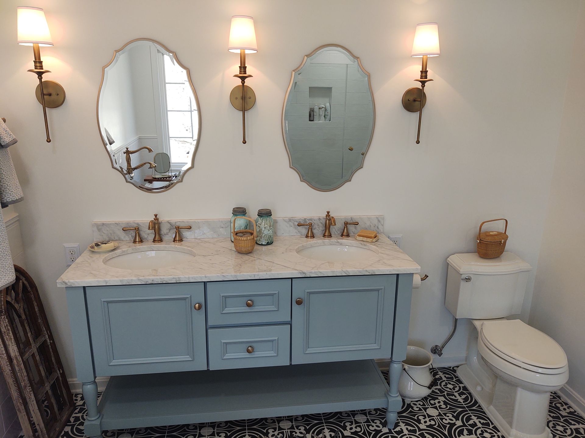 A bathroom with two sinks , two mirrors and a toilet