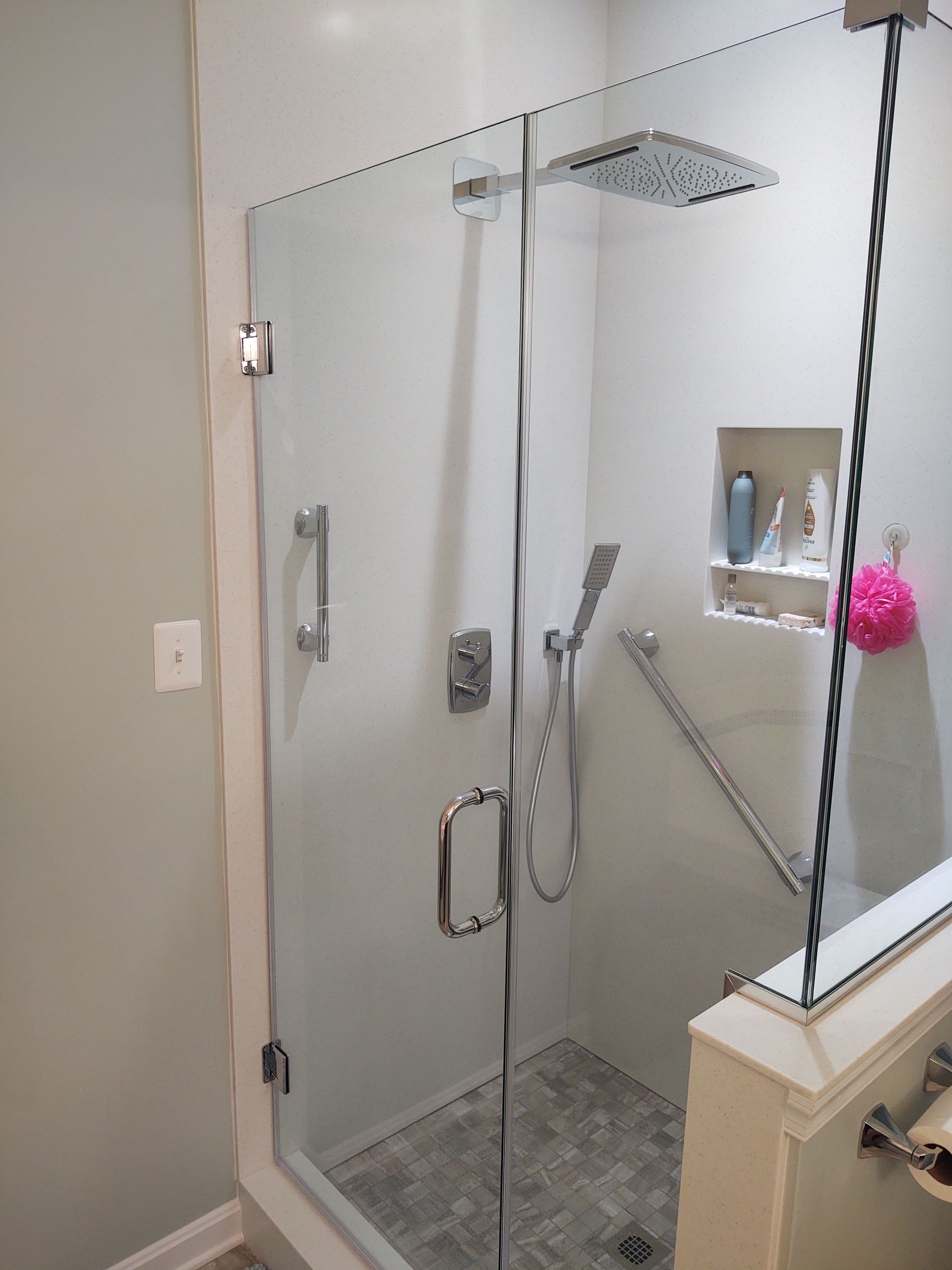 A bathroom with a glass shower door and a shower head.
