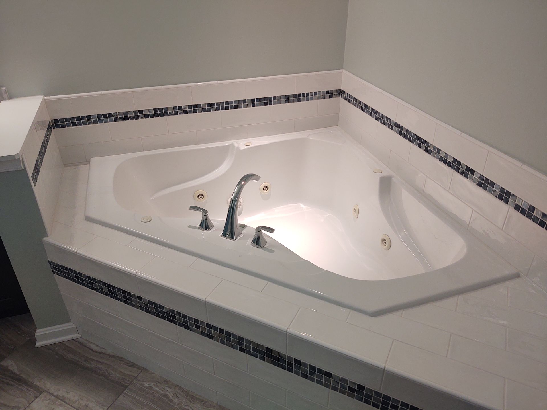A white jacuzzi tub with a faucet in a bathroom.
