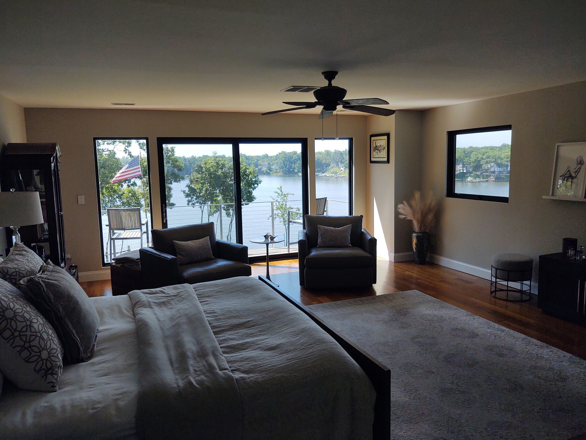 A bedroom with a large bed and a view of a lake