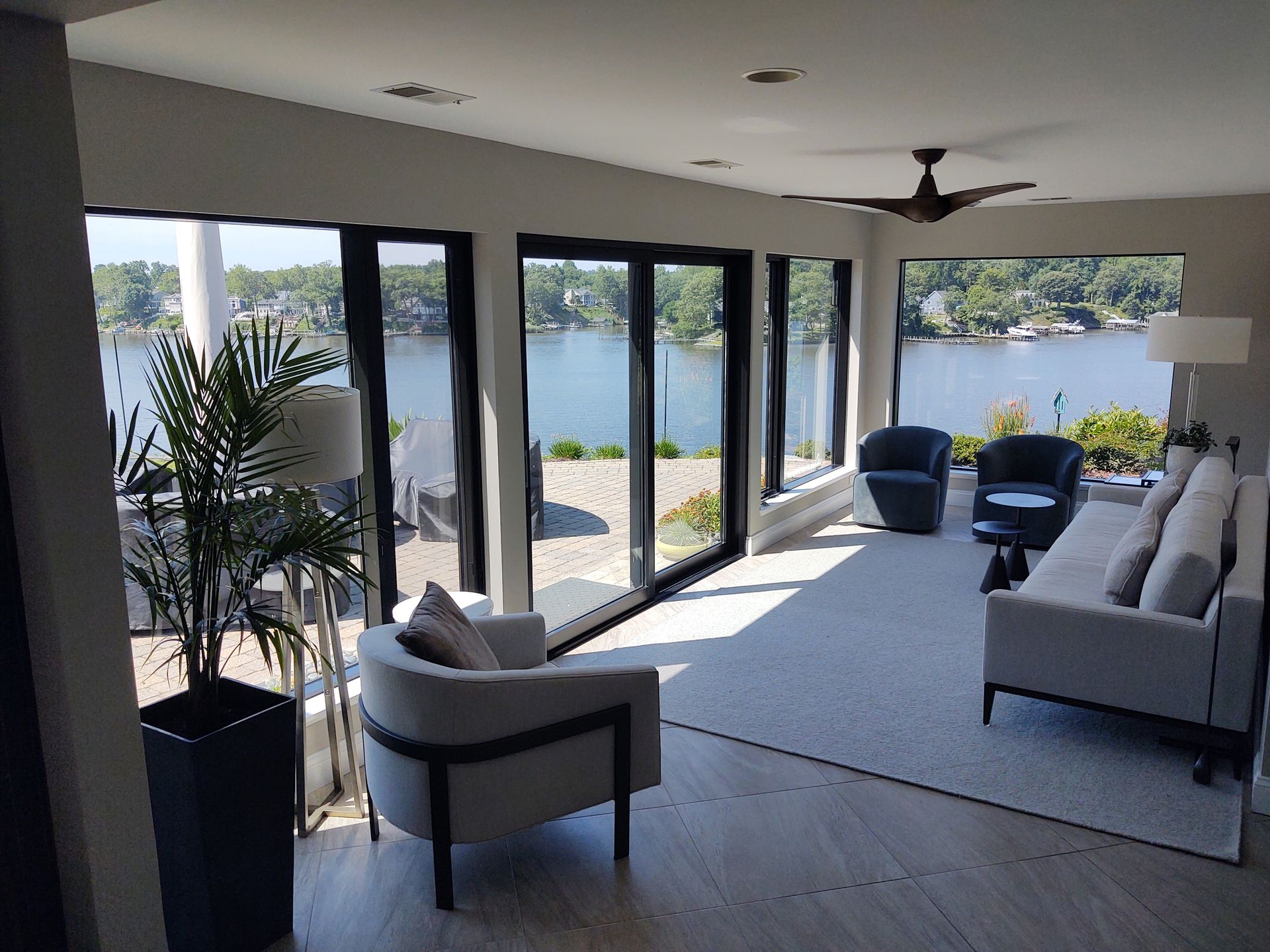 A living room with a lot of windows and a view of the water