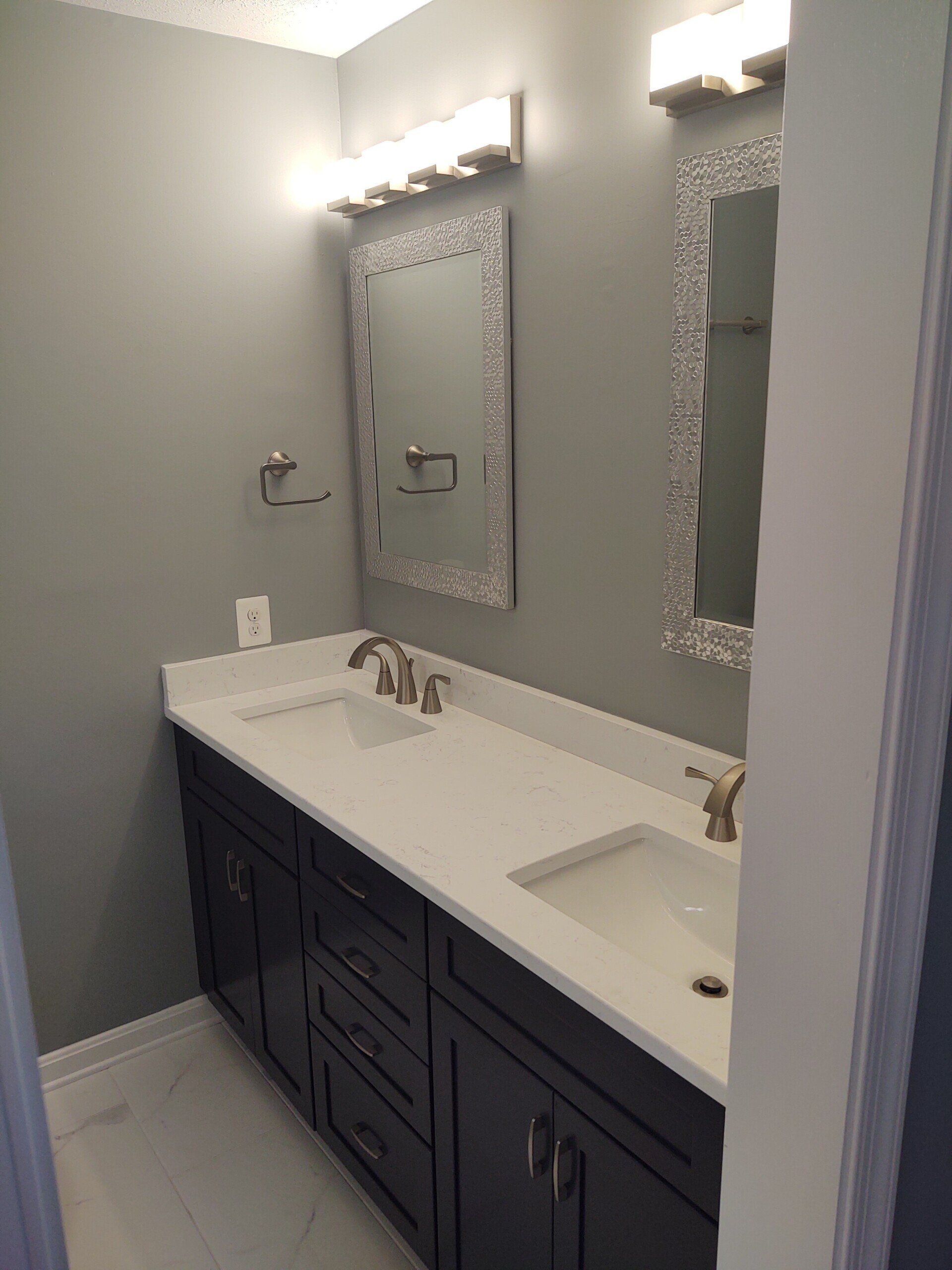 A bathroom with two sinks and two mirrors.