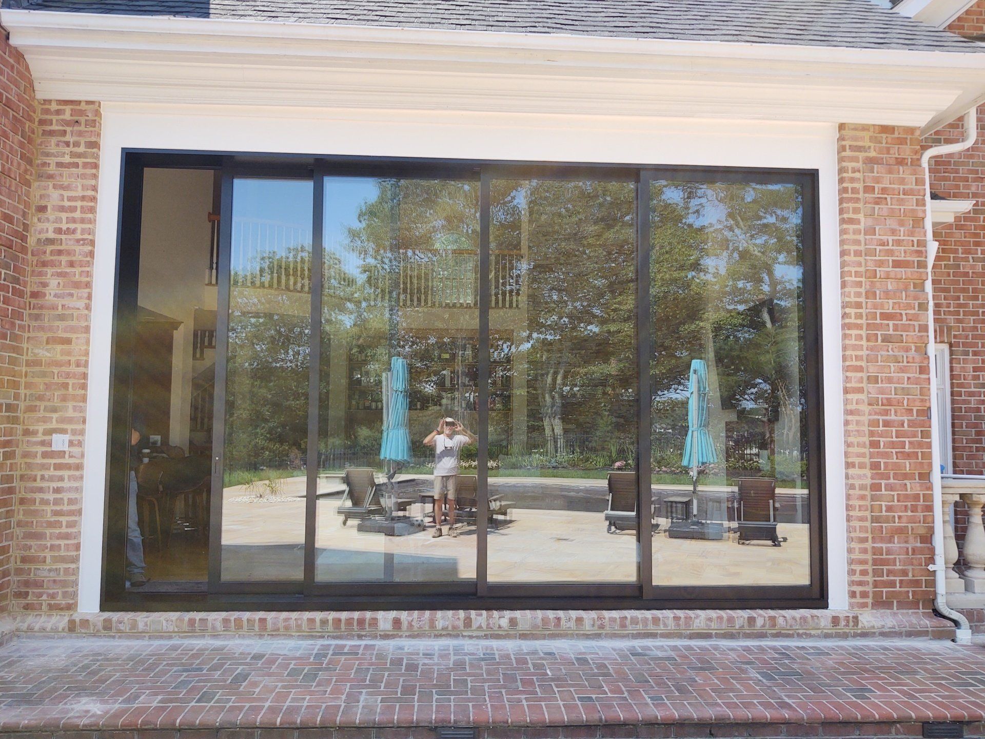 A brick house with a large sliding glass door leading to a patio