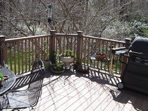 A deck with a table and chairs and a grill