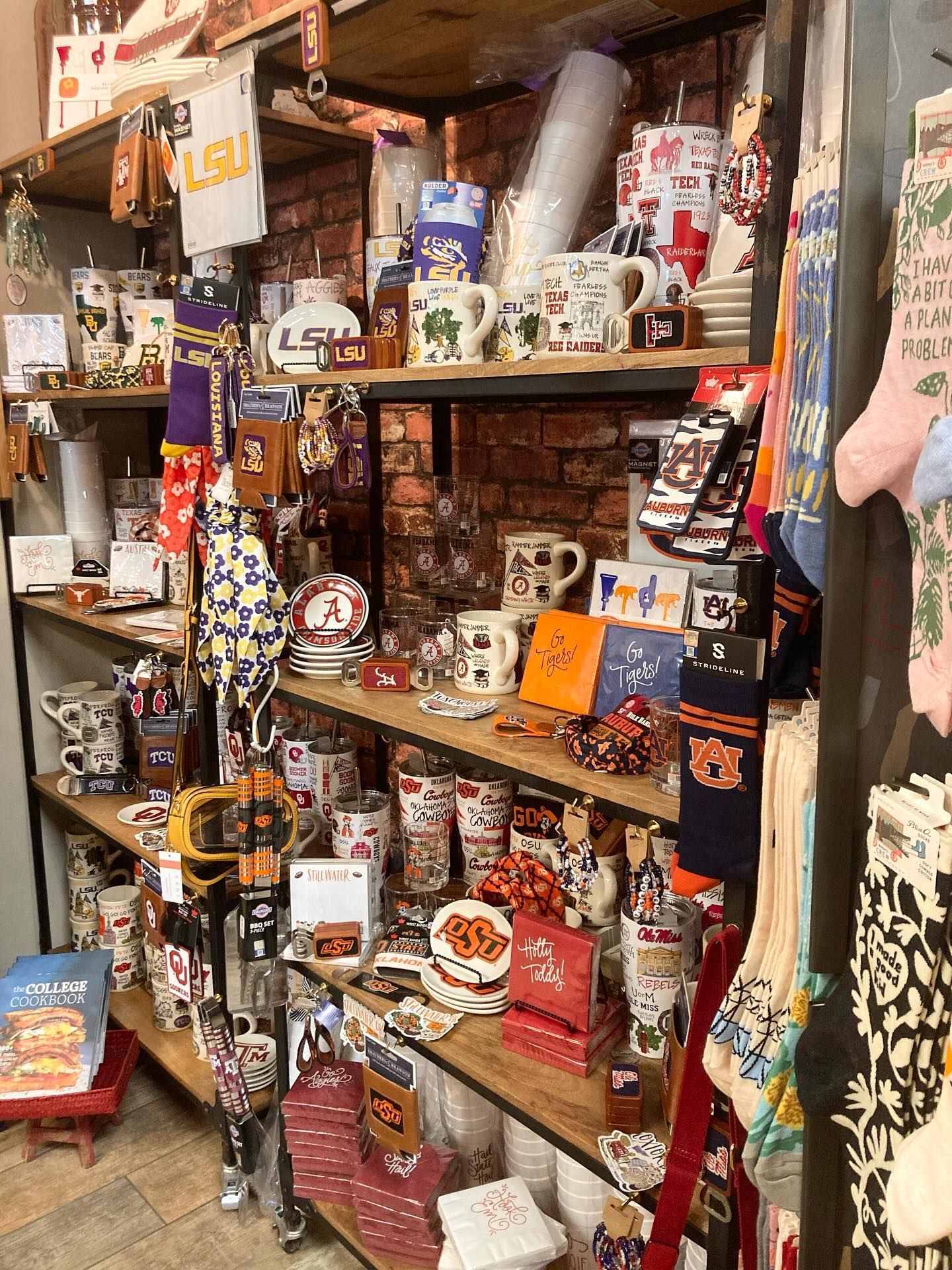 Shelves filled with LSU merchandise: mugs, flags, socks, and other items in a store.
