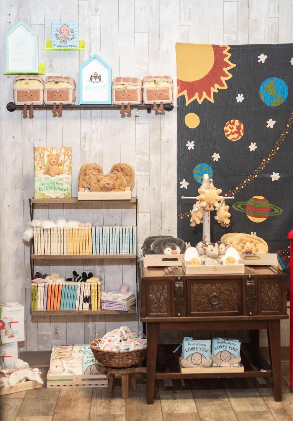 A children's store display featuring stuffed animals, books, and home decor items.
