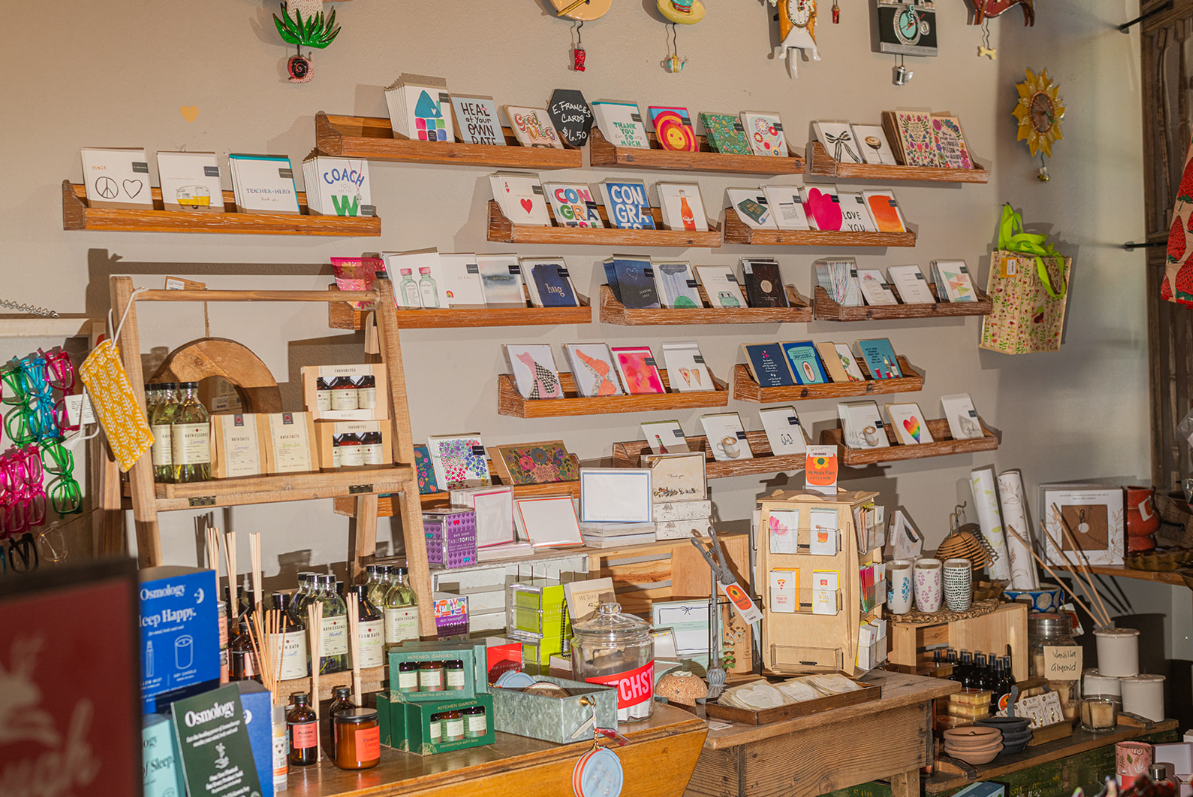 Interior shop with shelves displaying greeting cards, gifts, and goods.
