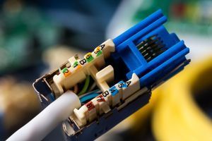 A close up of a computer cable with a blue connector.