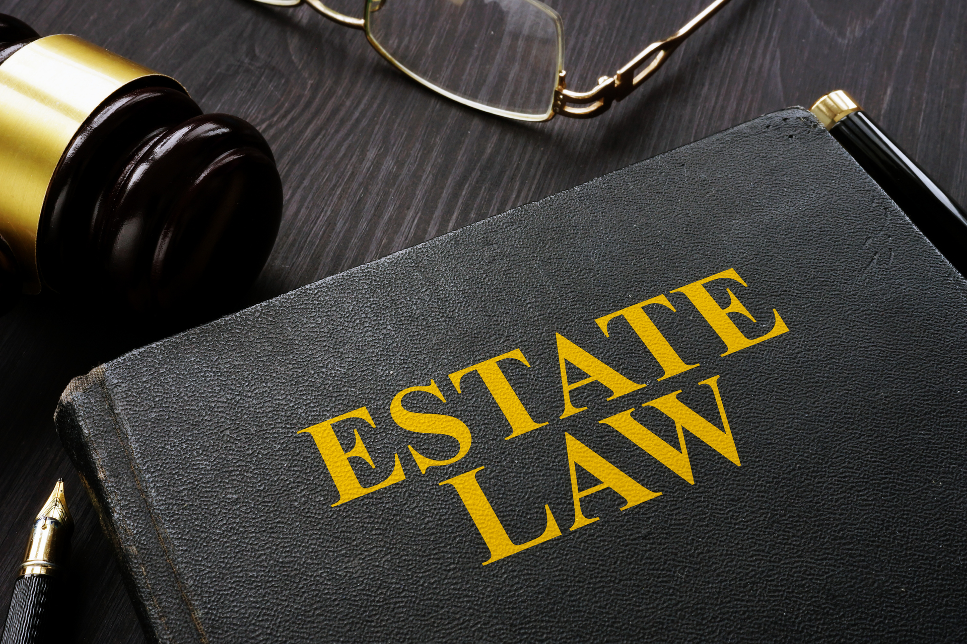 Real estate law book and gavel resting on wooden table.