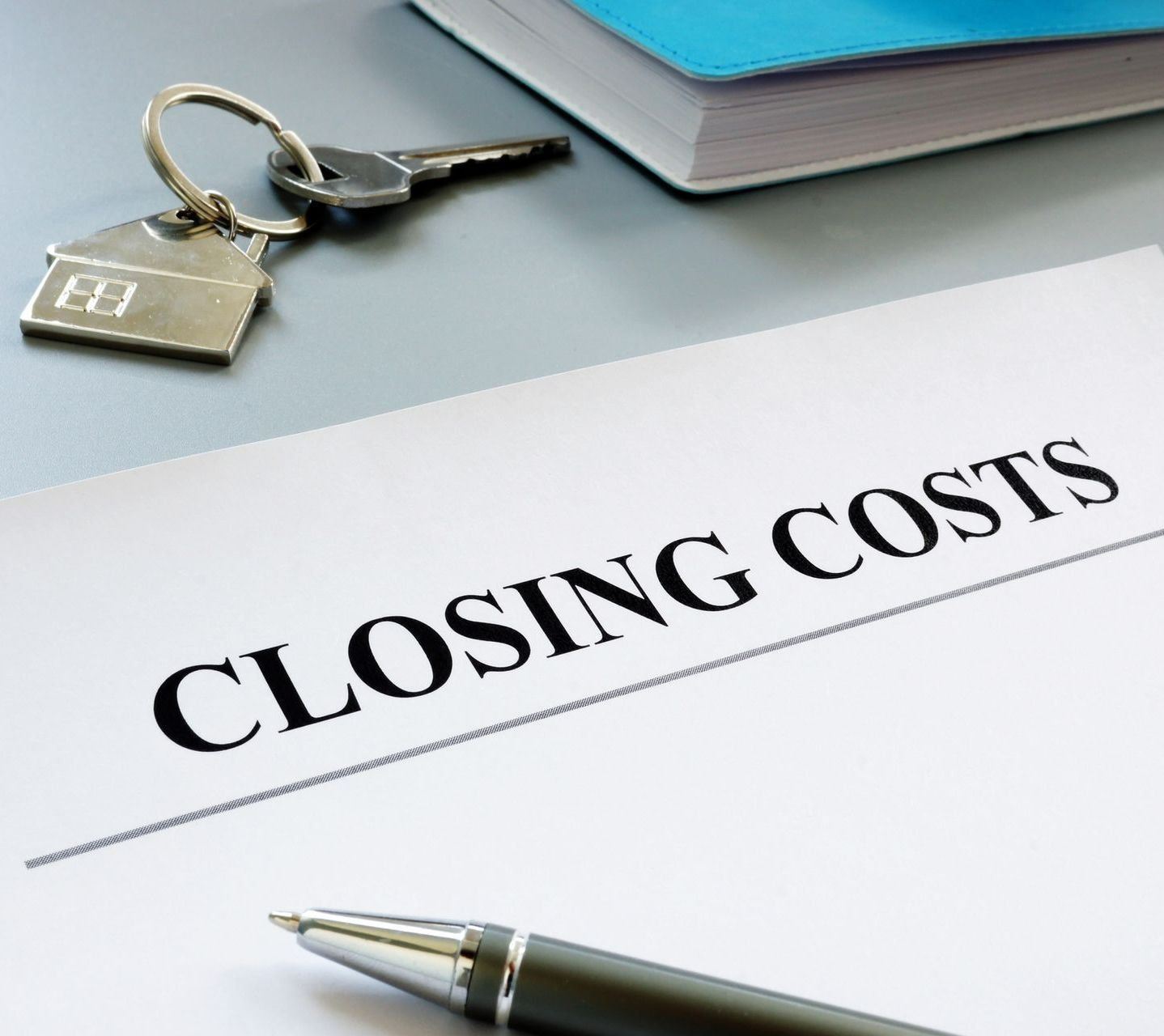A pen is on a piece of paper that says closing costs