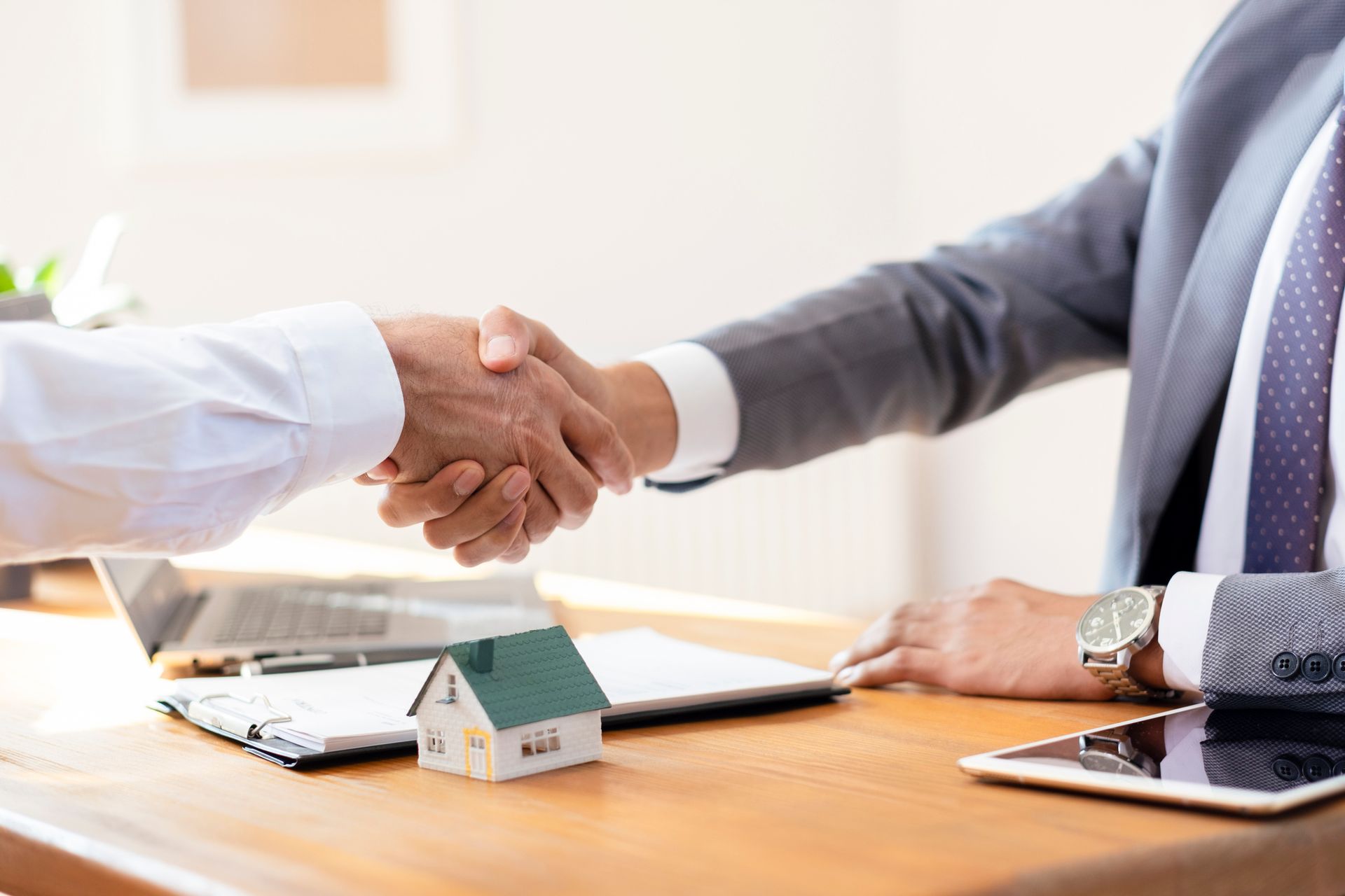 A man in a suit and tie is shaking hands with another man.