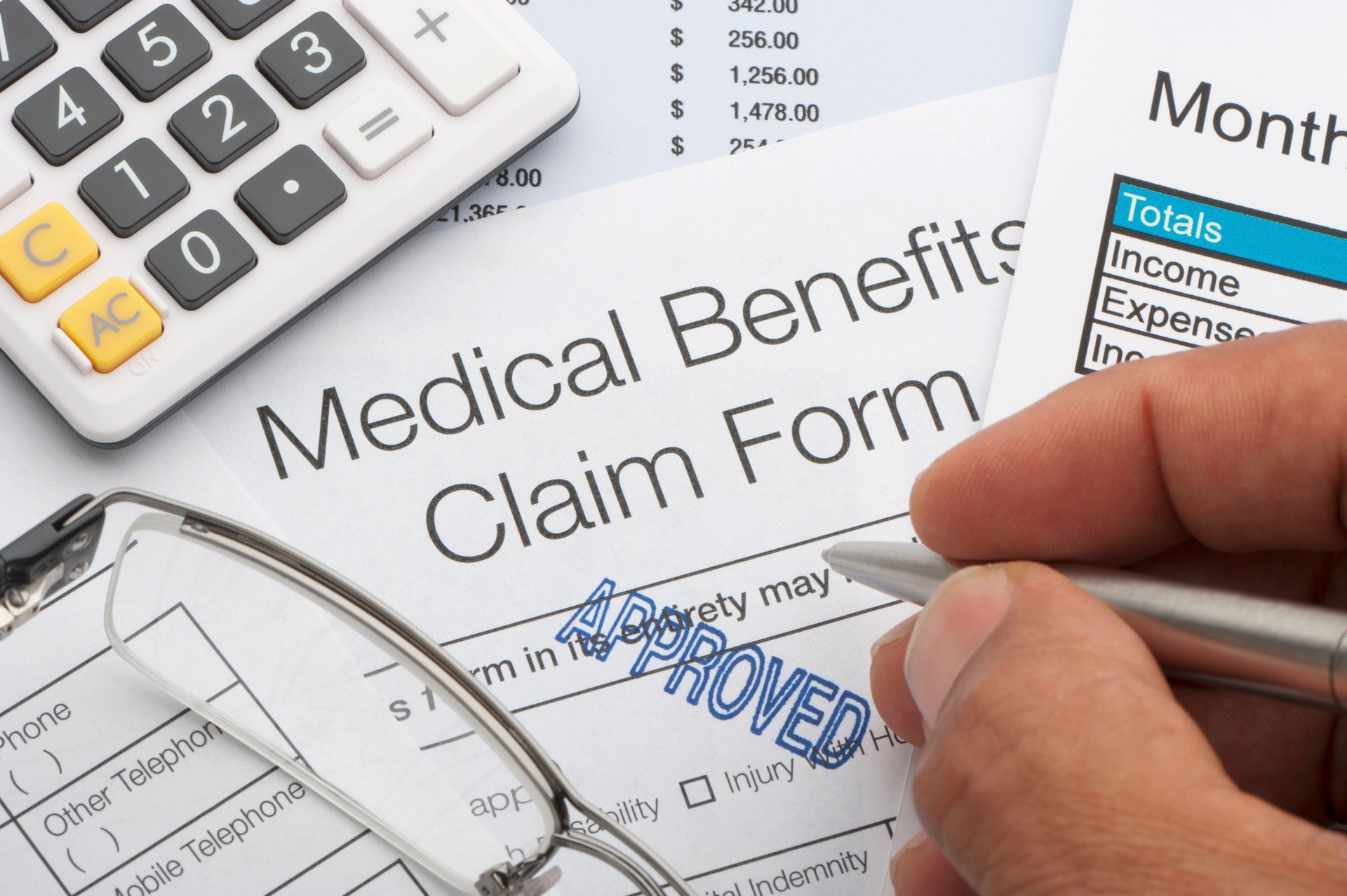 A person is filling out a medical benefits claim form