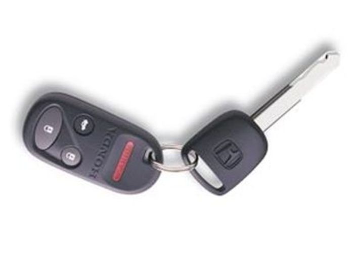Black car key fob with buttons and a metal key on a white background