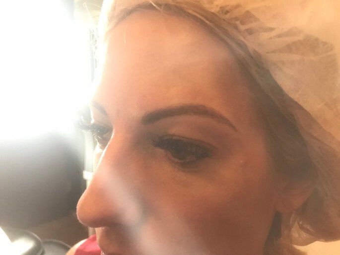 Woman's profile with light skin, one visible eye, and enhanced eyebrow; wearing a light head covering.
