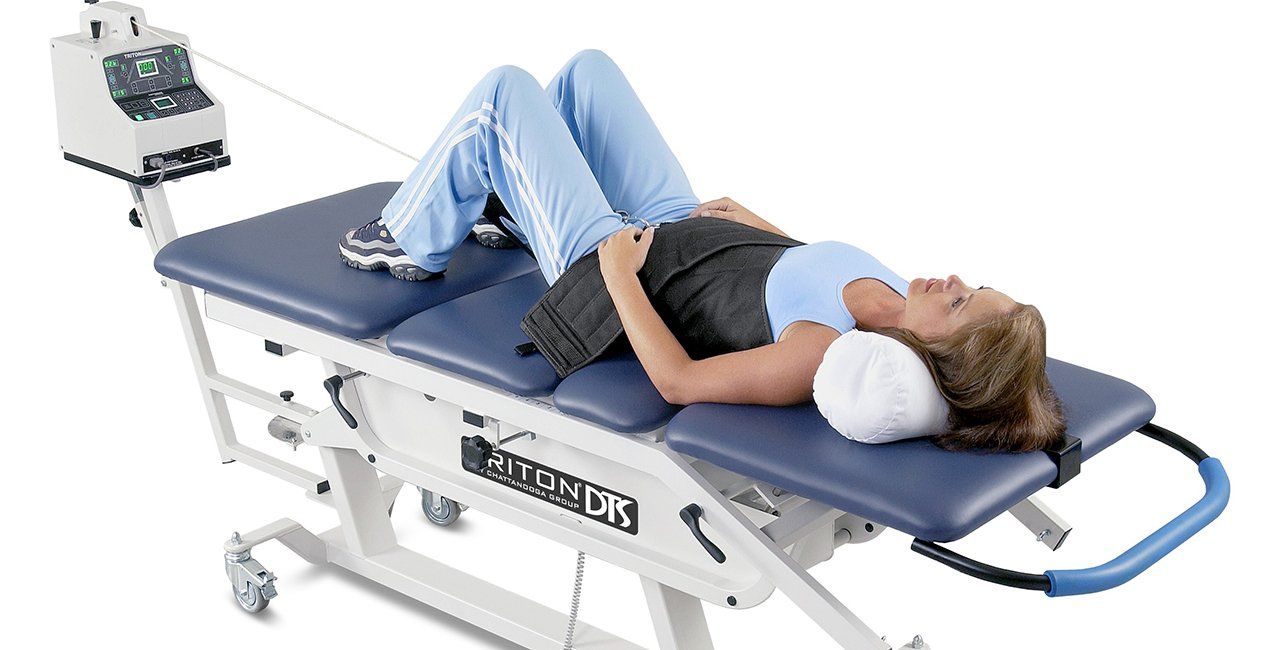 Woman undergoing spinal decompression therapy on a treatment table.